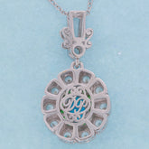 Elegant Oval Blue Opal Sterling Silver Pendant featuring intricate design and sparkling gemstone accents.